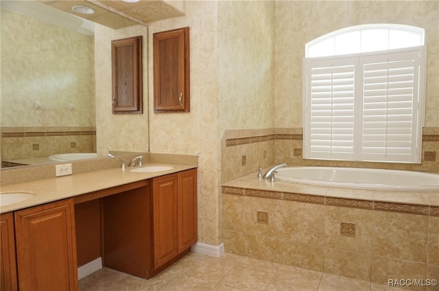 bathroom featuring tile patterned flooring, vanity, and a relaxing tiled tub