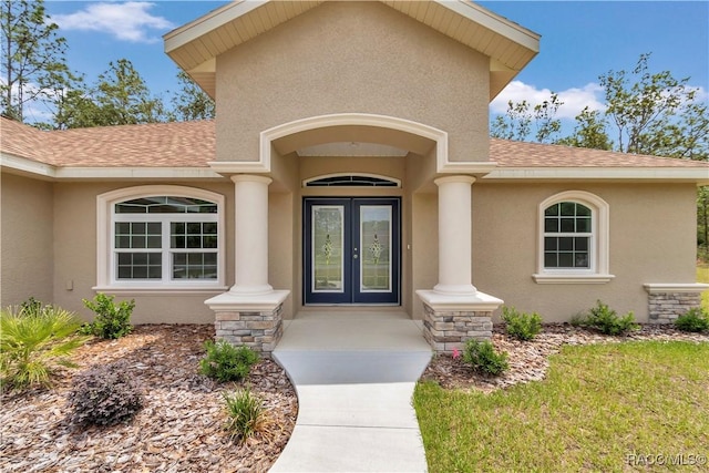 5443 N Nakoma Dr, Beverly Hills, FL 34465 - view of exterior entry featuring french doors, roof with shingles, and stucco siding