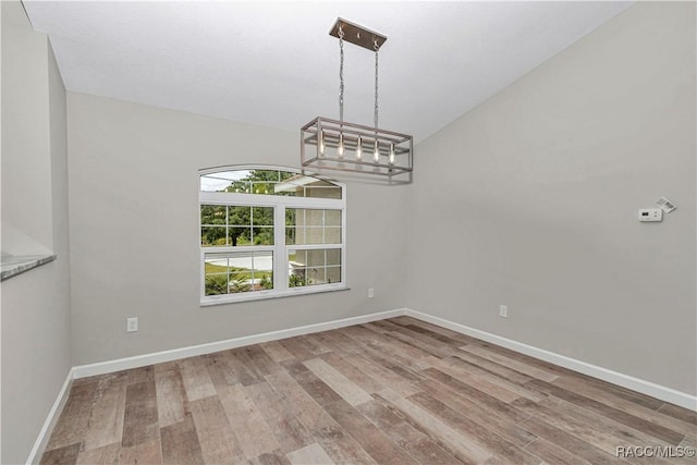 5443 N Nakoma Dr, Beverly Hills, FL 34465 - unfurnished dining area with wood finished floors, a chandelier, and lofted ceiling
