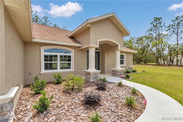 5443 N Nakoma Dr, Beverly Hills, FL 34465 - property entrance featuring stucco siding, roof with shingles, and a yard