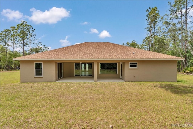 5443 N Nakoma Dr, Beverly Hills, FL 34465 - rear view of house with stucco siding, a patio, a shingled roof, and a yard