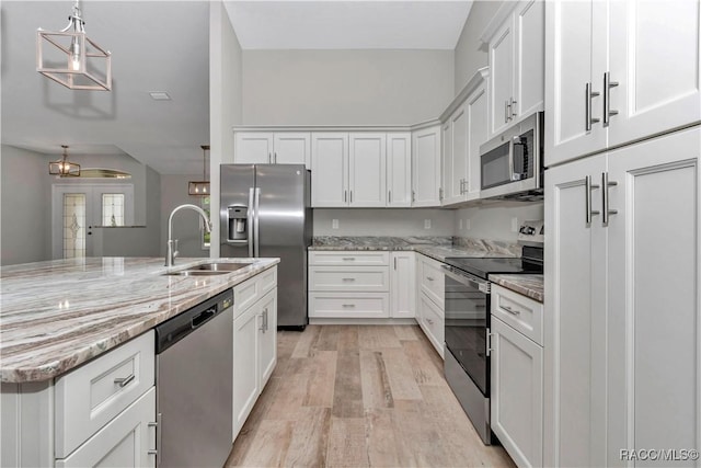 5443 N Nakoma Dr, Beverly Hills, FL 34465 - kitchen with stainless steel appliances, light wood finished floors, white cabinets, light stone countertops, and pendant lighting