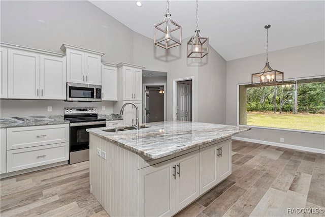 5443 N Nakoma Dr, Beverly Hills, FL 34465 - kitchen featuring appliances with stainless steel finishes, white cabinetry, high vaulted ceiling, an island with sink, and light wood finished floors