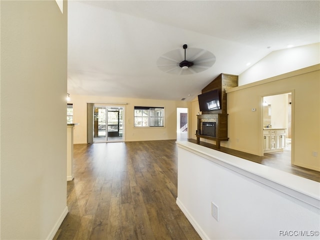 hallway with wood-type flooring and vaulted ceiling