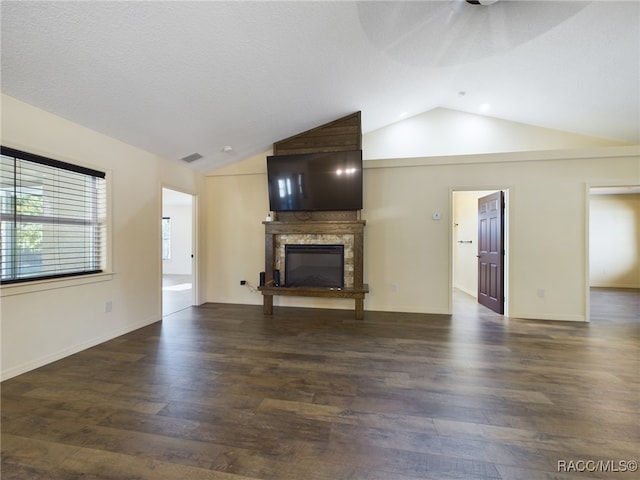 unfurnished living room with a fireplace, a textured ceiling, dark hardwood / wood-style floors, and lofted ceiling