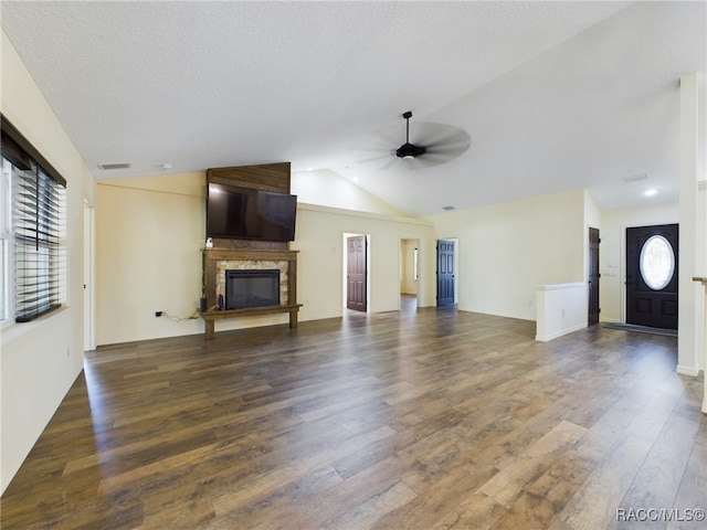 unfurnished living room featuring lofted ceiling, a high end fireplace, dark hardwood / wood-style floors, ceiling fan, and a textured ceiling