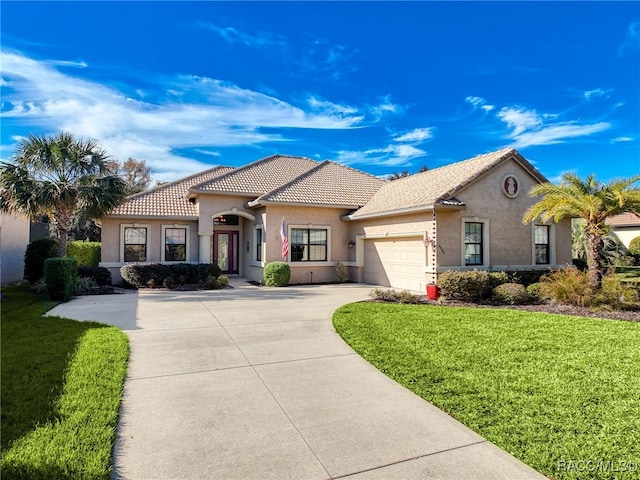 mediterranean / spanish house with a front lawn and a garage