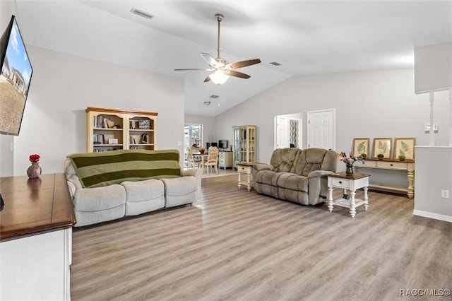 living room featuring vaulted ceiling, light hardwood / wood-style floors, and ceiling fan