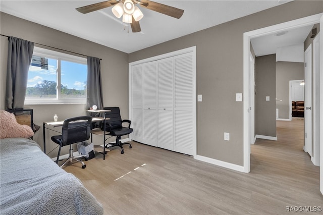 bedroom with a closet, ceiling fan, and light hardwood / wood-style flooring