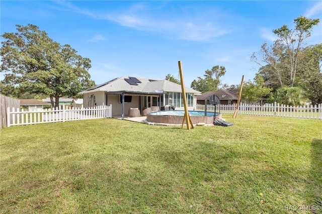 view of yard featuring a sunroom and a fenced in pool