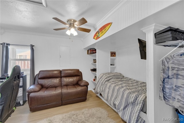 bedroom featuring ceiling fan, crown molding, a textured ceiling, and light hardwood / wood-style flooring