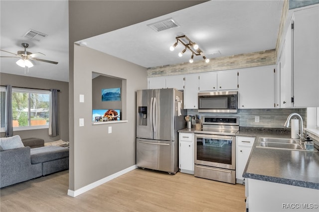 kitchen featuring light wood-type flooring, stainless steel appliances, ceiling fan, sink, and white cabinetry