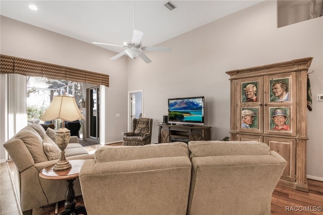 living room featuring a high ceiling, ceiling fan, and light hardwood / wood-style floors