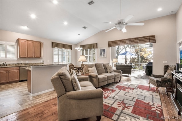 living room with lofted ceiling, sink, ceiling fan with notable chandelier, and light hardwood / wood-style floors