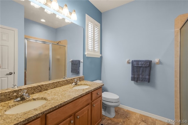 bathroom featuring toilet, vanity, and a shower with shower door