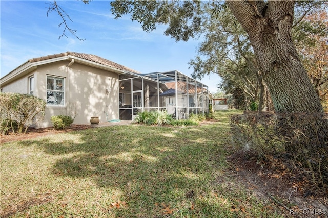 rear view of property featuring a lanai and a yard