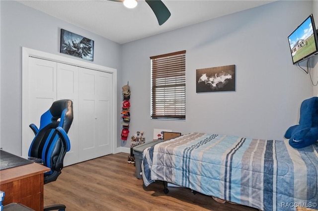 bedroom with ceiling fan, wood-type flooring, and a closet