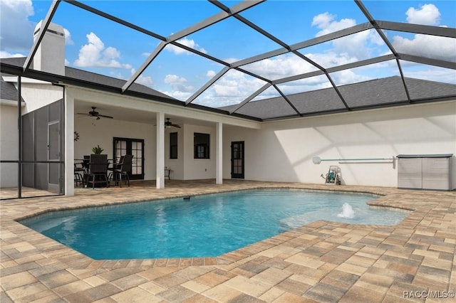 view of pool with french doors, pool water feature, ceiling fan, a lanai, and a patio