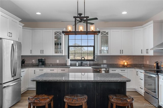 kitchen featuring a kitchen island, a kitchen bar, sink, and appliances with stainless steel finishes