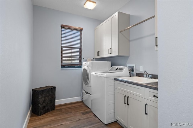 clothes washing area featuring separate washer and dryer, sink, cabinets, and dark hardwood / wood-style floors