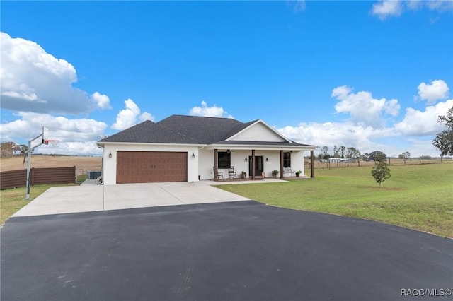 view of front of house featuring a porch, a garage, and a front lawn