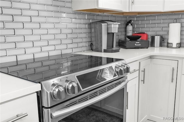 details with white cabinetry, stainless steel range with electric stovetop, and tasteful backsplash