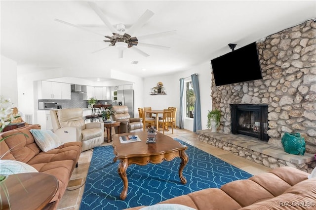 living room with ceiling fan and a fireplace