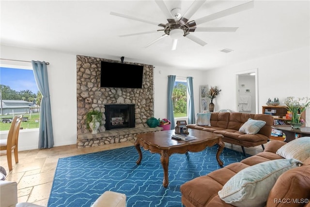 living room featuring ceiling fan and a fireplace