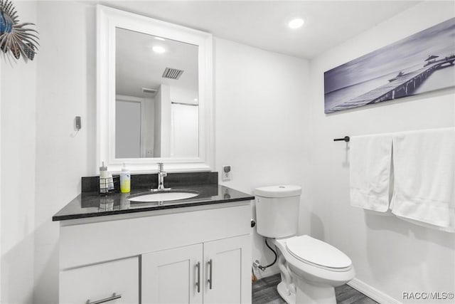 bathroom featuring hardwood / wood-style flooring, vanity, and toilet