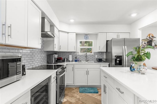 kitchen with white cabinetry, stainless steel appliances, sink, and backsplash