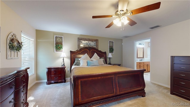 carpeted bedroom with ceiling fan, sink, and ensuite bath