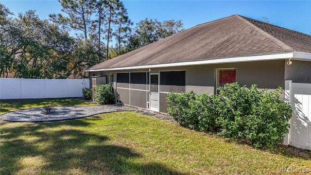 view of side of property with a yard and an outdoor fire pit