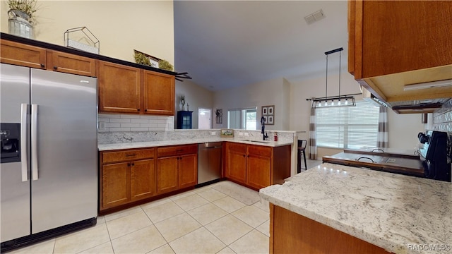 kitchen with lofted ceiling, sink, hanging light fixtures, kitchen peninsula, and stainless steel appliances