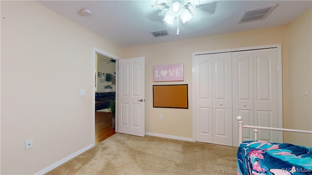 carpeted bedroom featuring ceiling fan and a closet