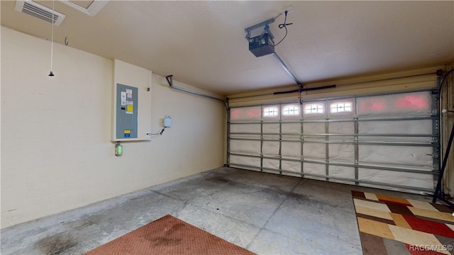 garage with a garage door opener and electric panel