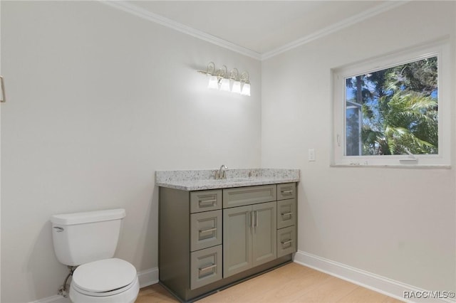 bathroom with toilet, baseboards, ornamental molding, and vanity