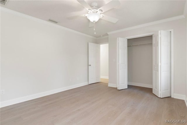 unfurnished bedroom featuring light wood-type flooring, visible vents, crown molding, and baseboards