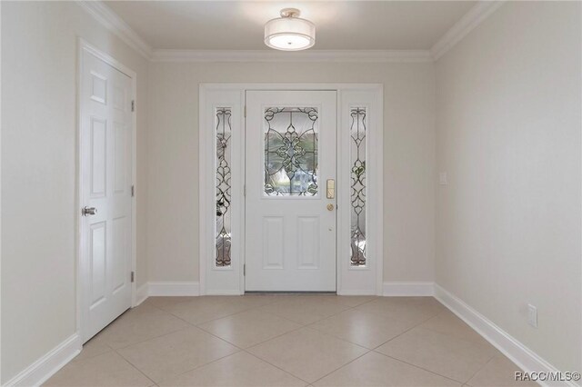 foyer with ornamental molding, baseboards, and light tile patterned floors