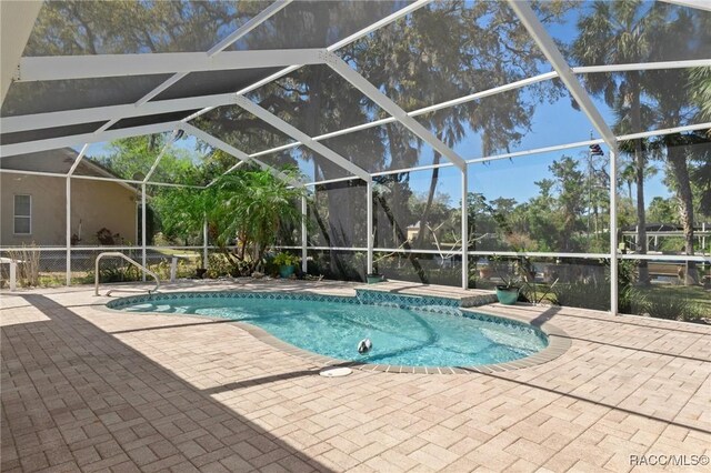 pool with glass enclosure and a patio