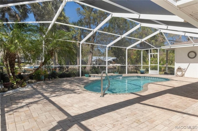 outdoor pool with a patio and glass enclosure