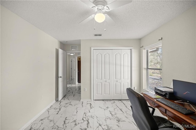 office space with a textured ceiling, marble finish floor, visible vents, and baseboards