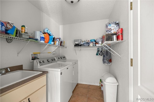 laundry room with washer and clothes dryer, a sink, a textured ceiling, laundry area, and tile patterned floors