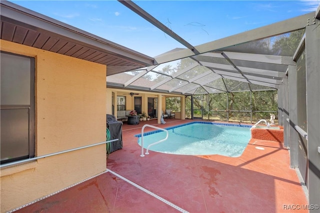 outdoor pool with glass enclosure and a patio area