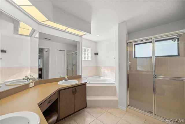 bathroom featuring a garden tub, a sink, a shower stall, tile patterned floors, and double vanity