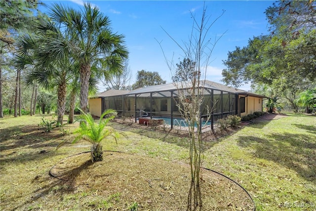 view of yard featuring glass enclosure and an outdoor pool