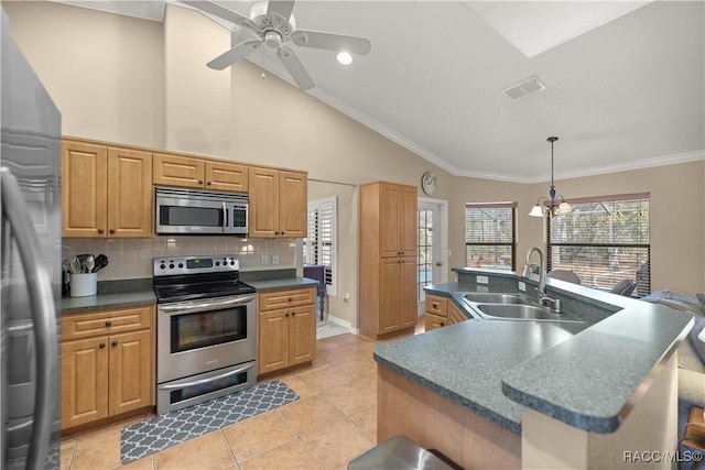 kitchen with a kitchen island with sink, a sink, appliances with stainless steel finishes, dark countertops, and crown molding