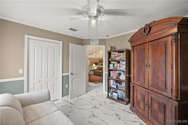 sitting room featuring visible vents, a ceiling fan, marble finish floor, a textured ceiling, and crown molding