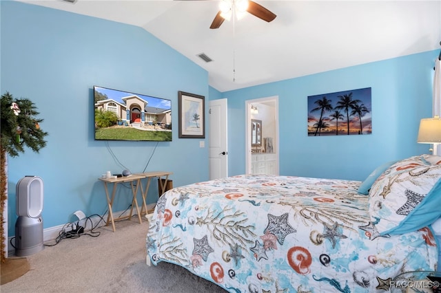 bedroom featuring ceiling fan, carpet, ensuite bathroom, and vaulted ceiling