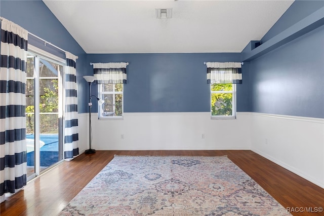 unfurnished room with dark hardwood / wood-style floors and vaulted ceiling