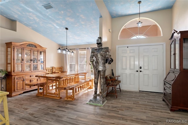 entryway featuring high vaulted ceiling, dark hardwood / wood-style floors, and a notable chandelier